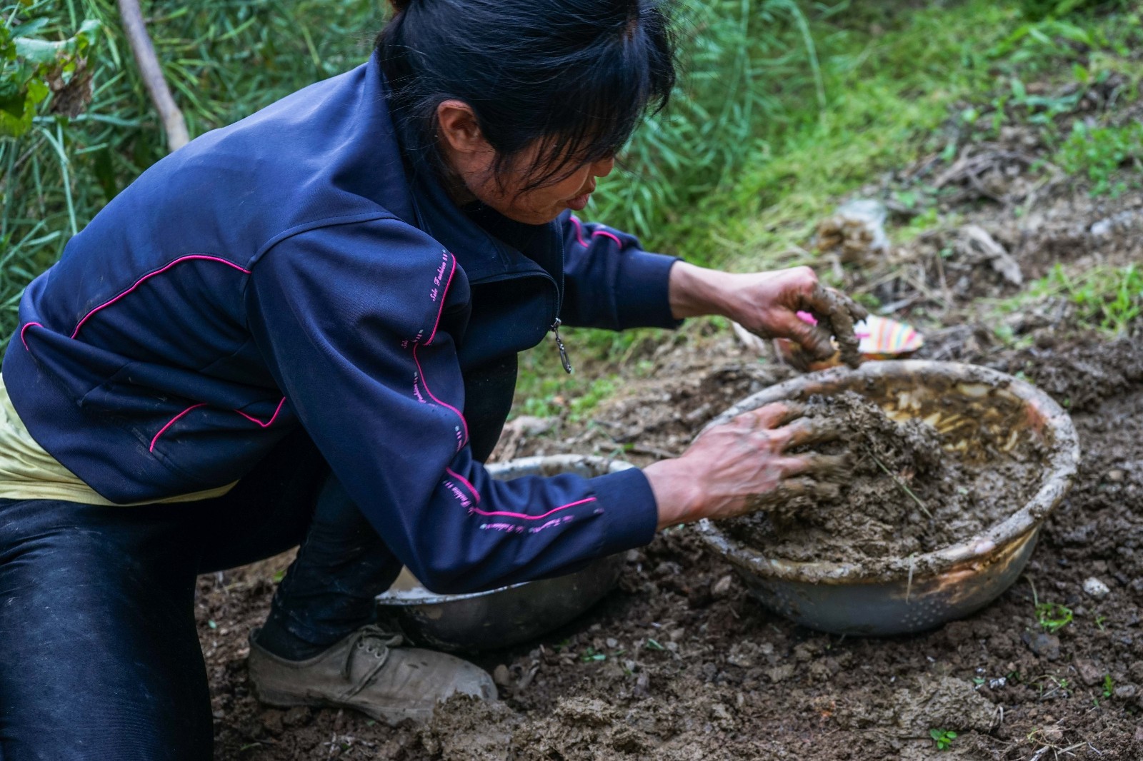 仡佬族妇女徒手用大粪汁和土,搓成一个个粪团.