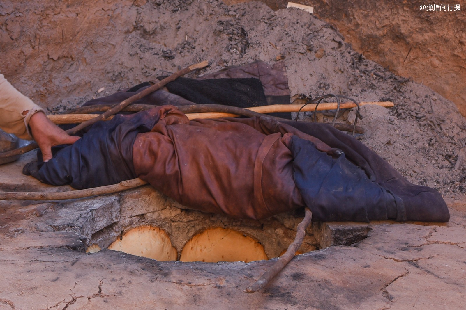 临别时,她从馕坑里取出一个热气腾腾的馕,硬让我们品尝.