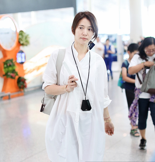 46岁袁咏仪现身机场穿宽松白衬衫好减龄丝巾绑马尾气质满分