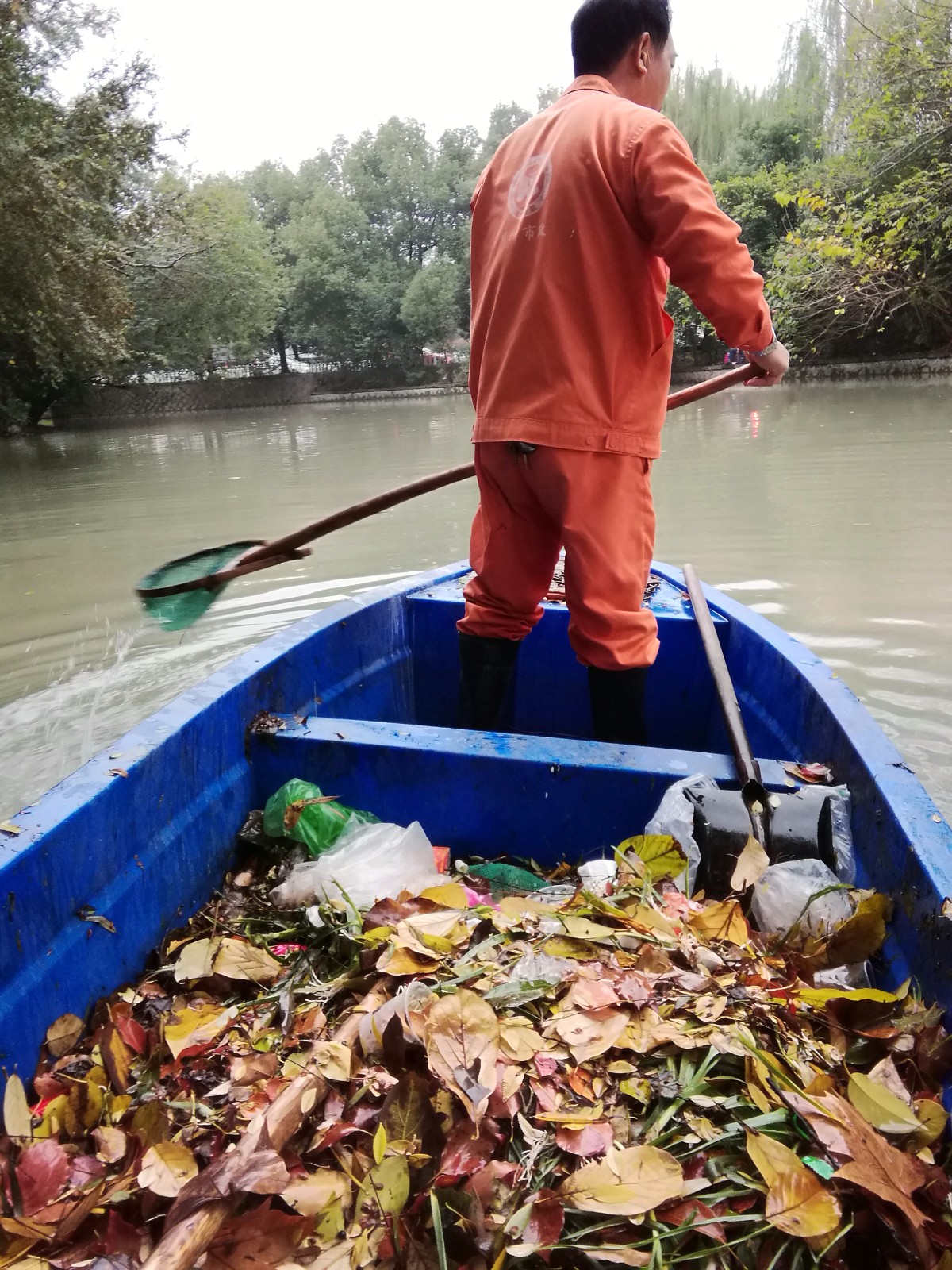 负责河面打捞垃圾的环卫工人,一天工资八十元