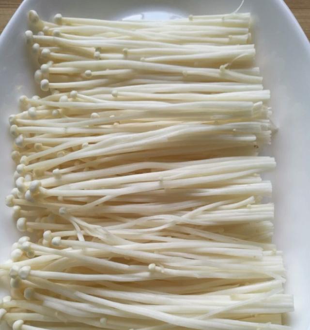 把洗好的金针菇放到一个盘子里金针菇1,金针菇切掉根部,然后撕成一根