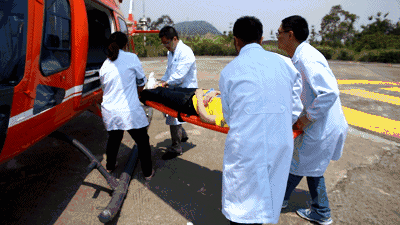 现场   医疗人员随即采用地空接驳   火速用特制担架将伤者送上直升机