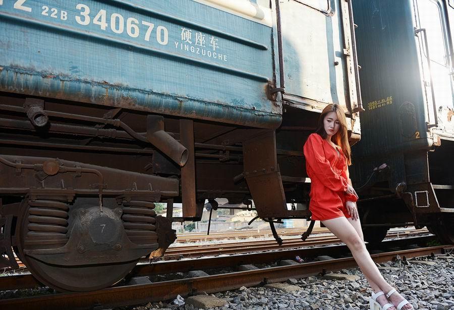 铁轨上的美丽红裙女子搭配束腰短裙白色高跟鞋