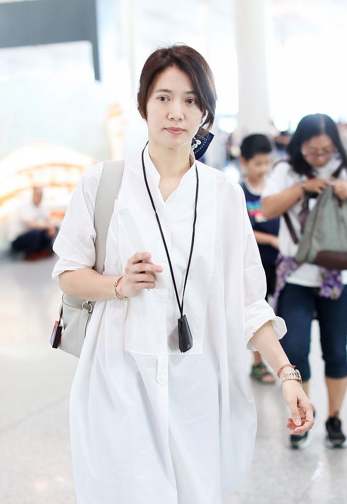 46岁袁咏仪现身机场穿宽松白衬衫好减龄丝巾绑马尾气质满分