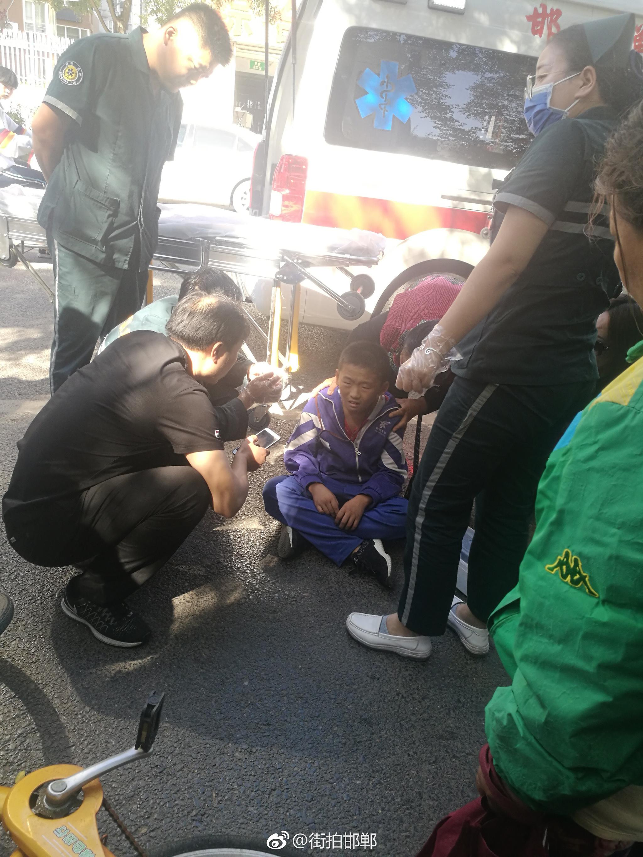 一位身着校服的学生晕倒在路旁