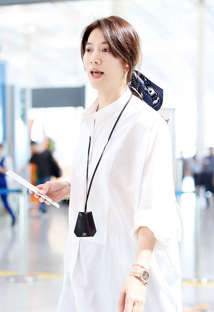 46岁袁咏仪现身机场穿宽松白衬衫好减龄丝巾绑马尾气质满分
