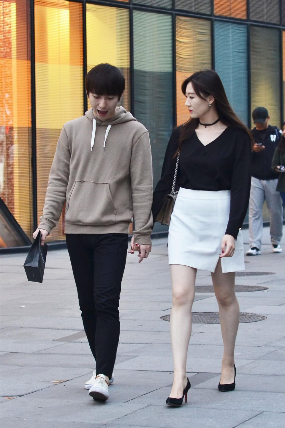 街拍美女一对逛街的小情侣女生白色套裙很有活力