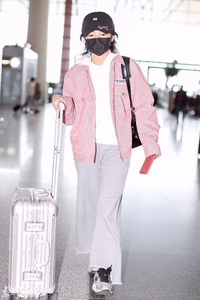 张子枫戴口罩穿粉色外套搭配灰色阔腿裤现身机场,看起来略显疲惫