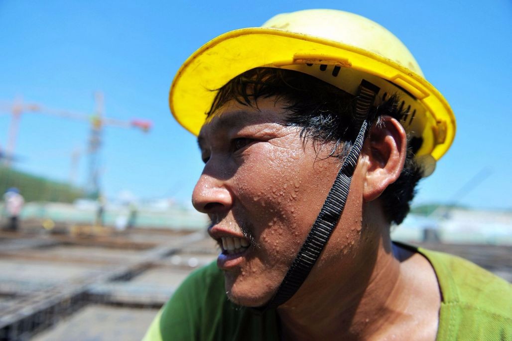 实拍高温下建筑工地农民工 汗流浃背 手中活不能停