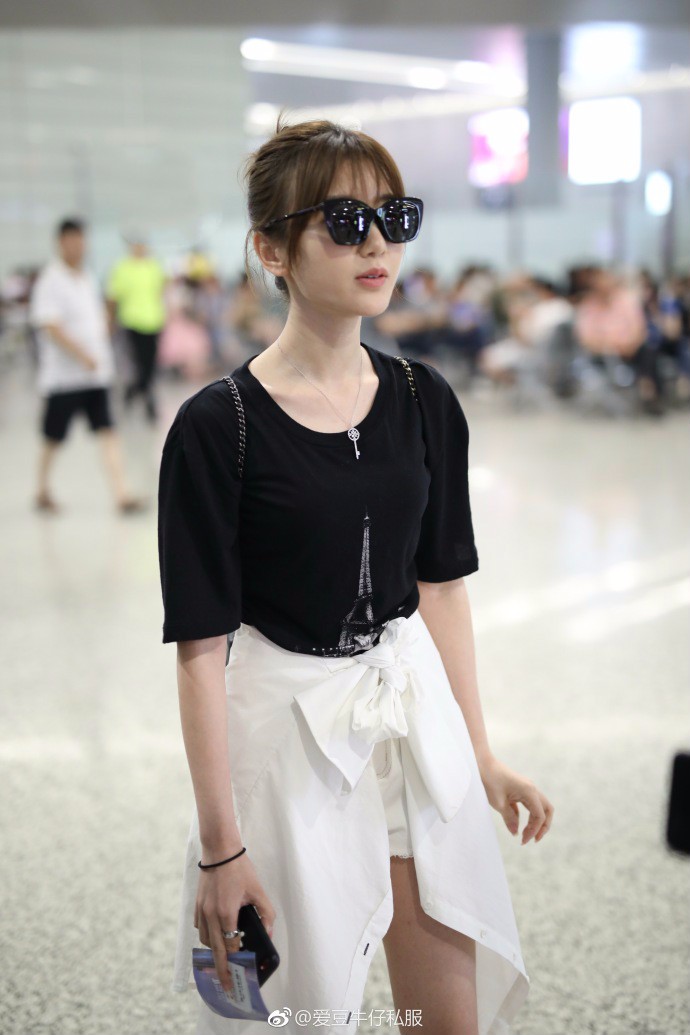 毛晓彤戴墨镜穿黑t恤搭配白短裤现身机场,把衣服绑在腰上很时髦