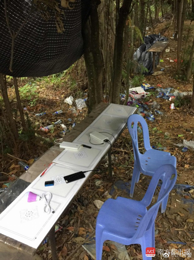 当一切准备就绪,真正的电信诈骗实施者则躲在小树林,架起小桌板,然后