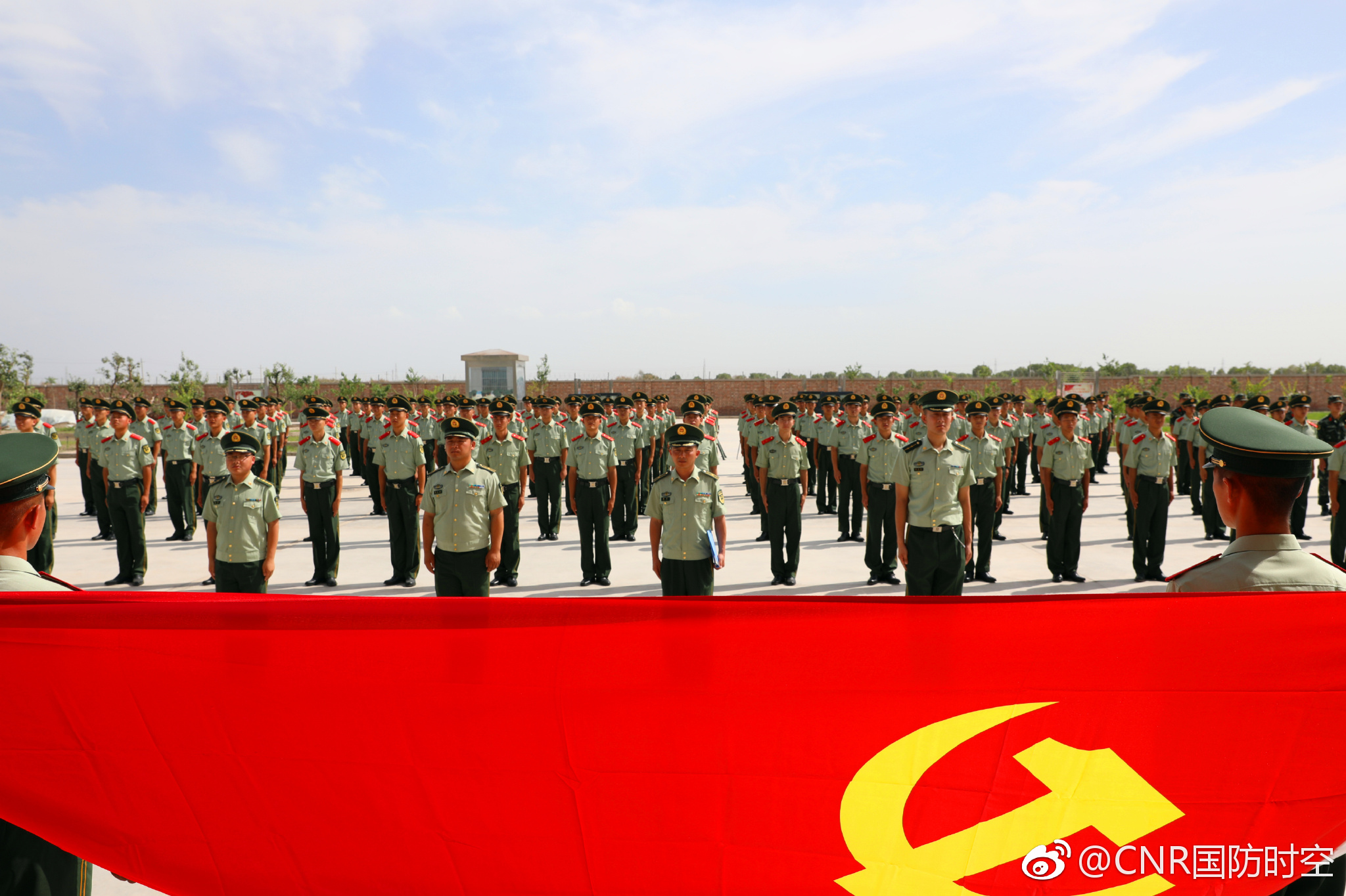 和入党积极分子在大队长杨韦的领誓下,面向党旗,高举右拳,庄严宣誓