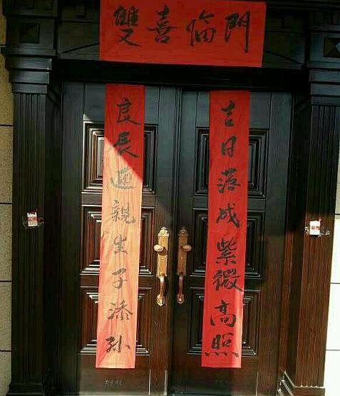 二楼门口,贴了喜庆的对联,吉日落成紫微高照,良辰迎亲生子添孙,写得