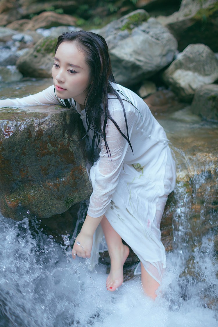 一个在山间泉水边的白衣女孩