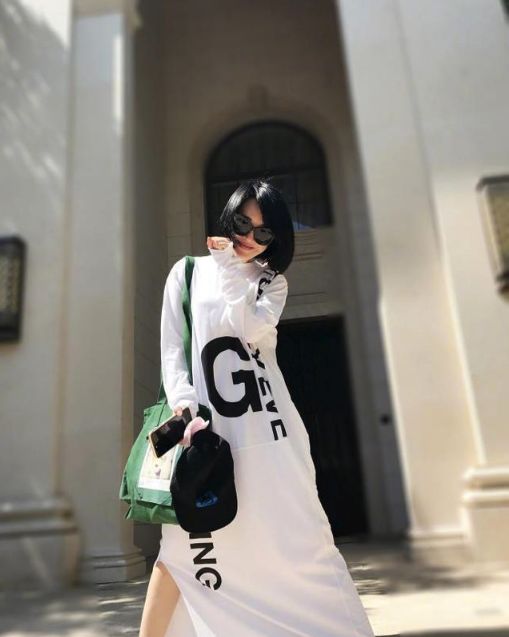 再来看看许晴,身穿白色衬衫裙,侧分短发,炫酷墨镜遮面,手拿相机拍照的