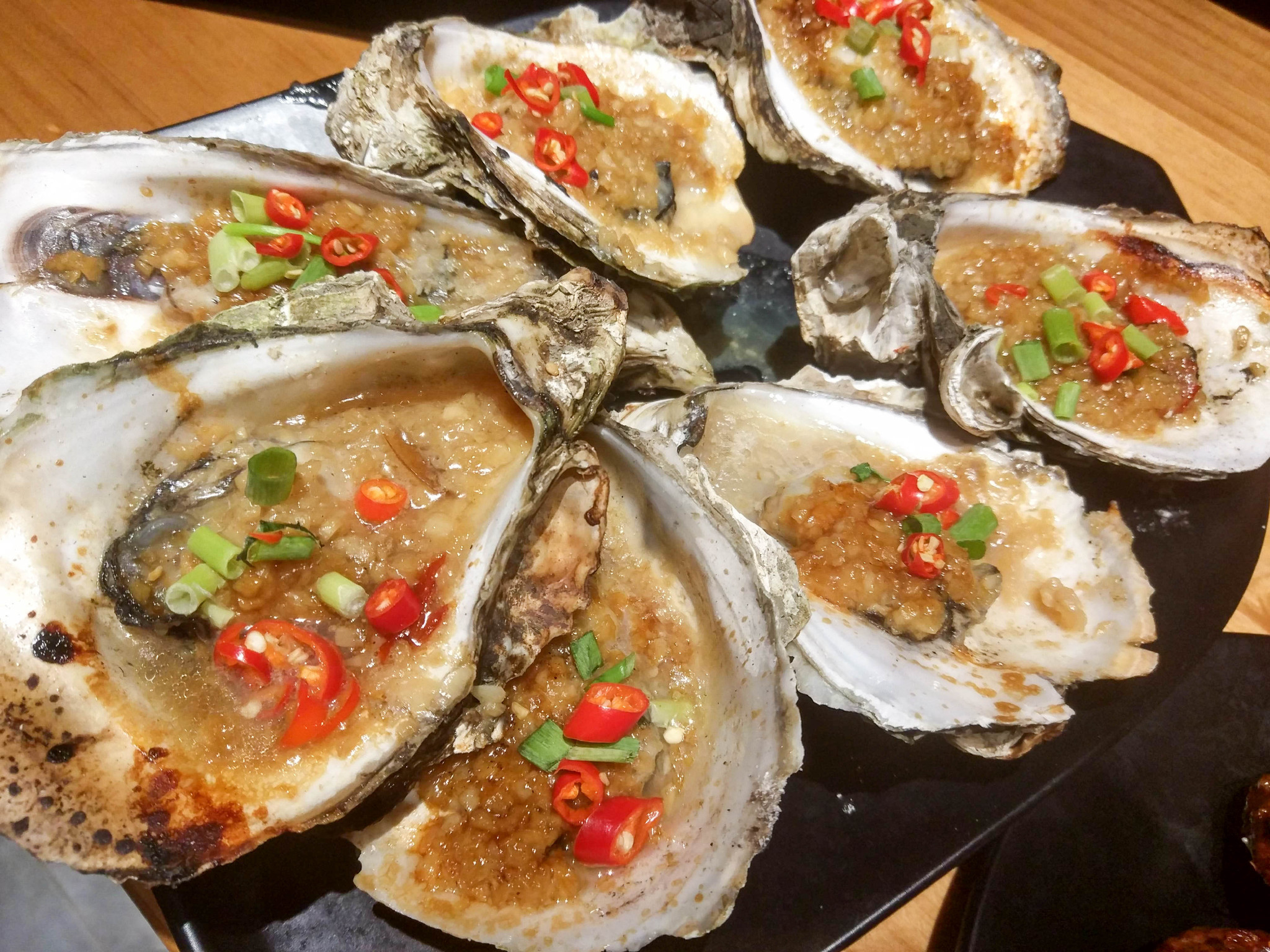 生蚝 生蚝很大,很新鲜,上面满满的蒜蓉,放到火上烤熟即可,蒜蓉下,那