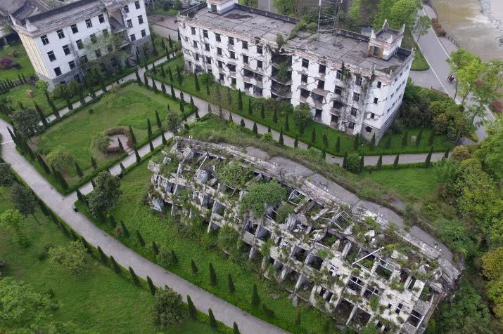 汶川地震10年，倒塌的教学楼和宿舍被保留，杂草丛生空无一人