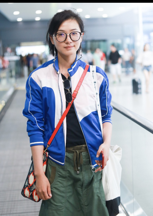 万茜带着黑框眼镜穿蓝白运动衣现身机场 对镜咬唇眯眼可爱十足