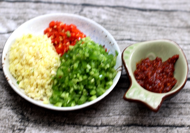 加入适量油,倒入豆瓣酱炒出红油,然后加入肉末翻炒加入姜蒜末,泡椒末