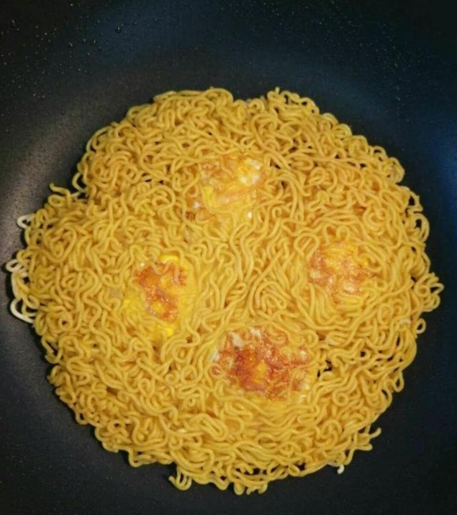 煎好之后盛出来放到案板上,切成块就可以吃了切方便面鸡蛋饼味道很不