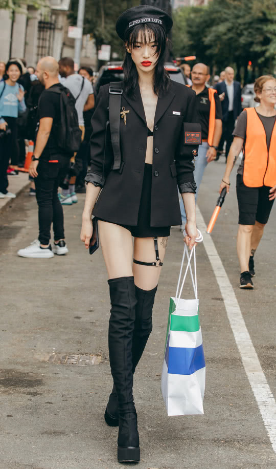 崔素拉身穿黑色的吊带裙,外搭一款黑色外套,脚踩一双黑色的短靴