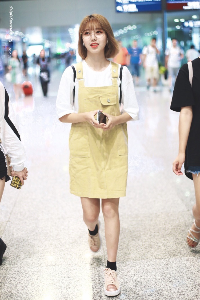 刘人语戴眼镜穿白t恤搭配背带裙现身机场 伸舌头搞怪笑容甜美
