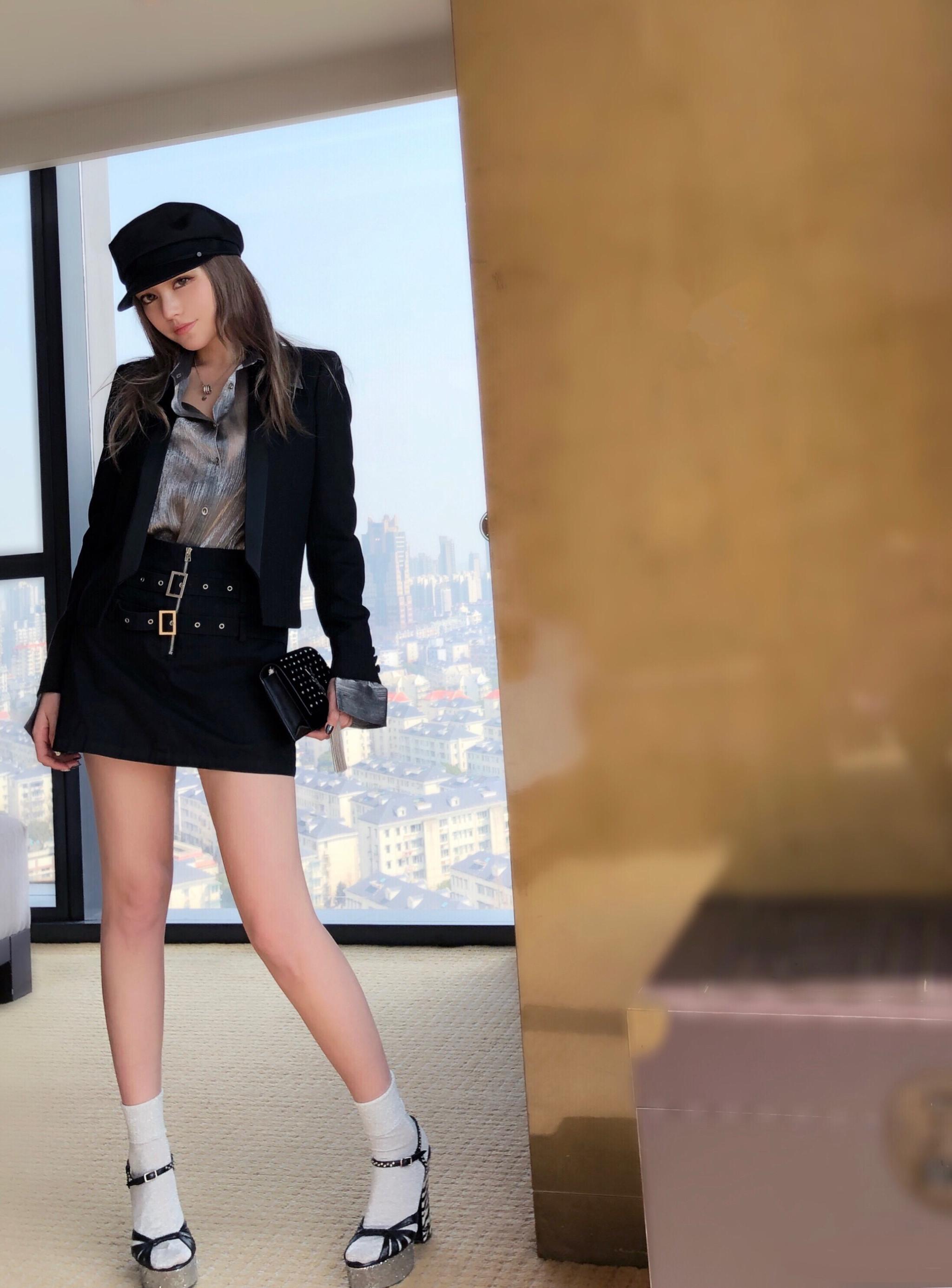 周扬青身穿银色衬衫,搭配黑色短裙大秀美腿,外搭黑色小西装,脚踩黑色