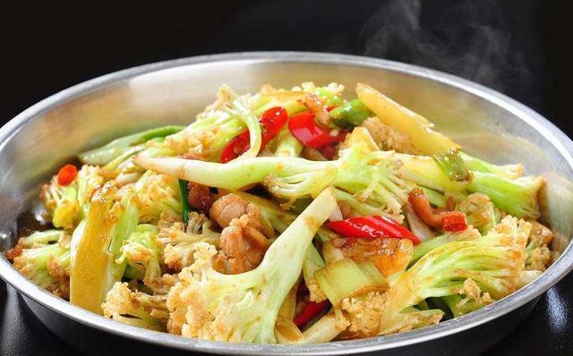 淋入生抽和料酒翻炒均匀,最后放入青蒜翻炒几下即可装入锅仔上桌