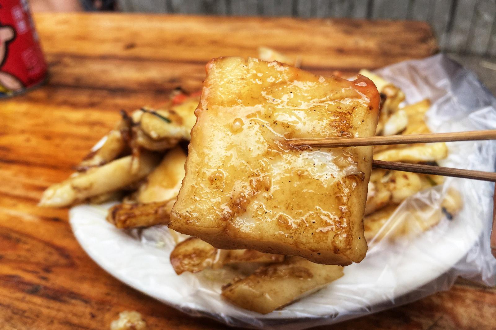 广东吴川的特色美食-烂镬炒粉,先用棍子把粉炒开,再放入蒜蓉,韭菜