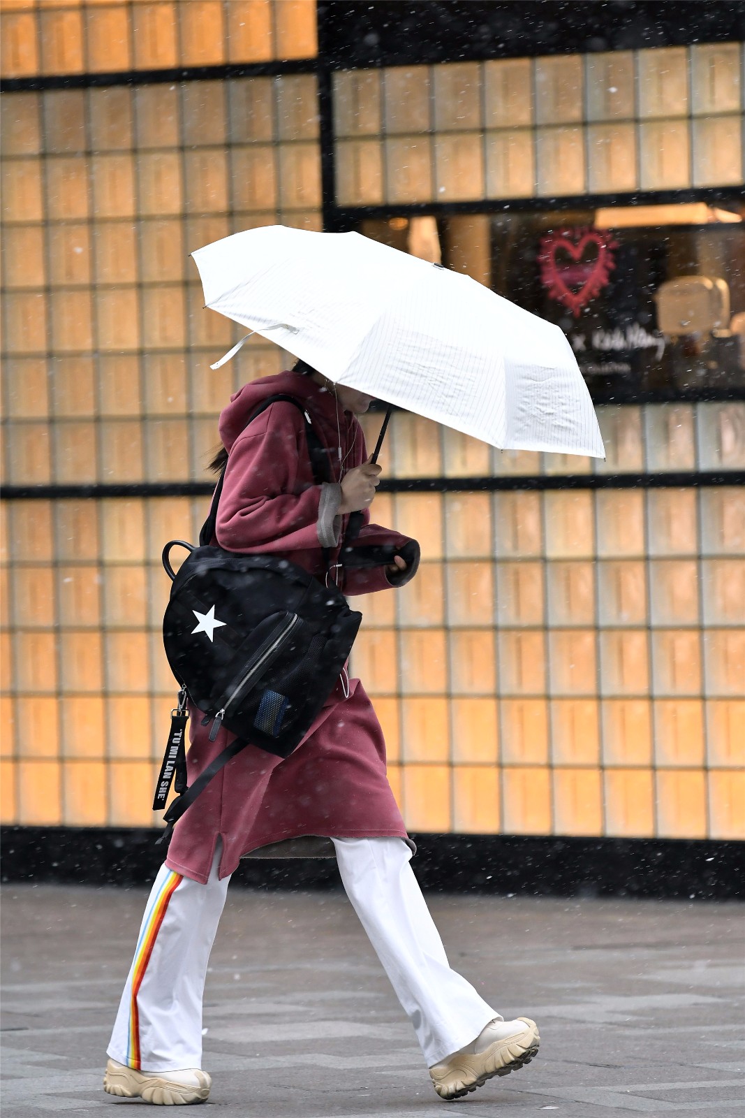 雨雪中的三里屯,依旧有时尚姑娘打伞前行逛街