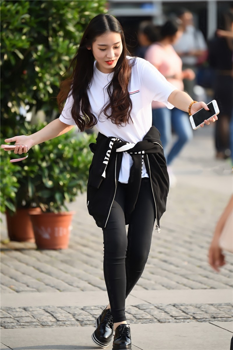 路人街拍外套扎在腰间的长发美女和闺蜜游戏玩的不亦乐乎