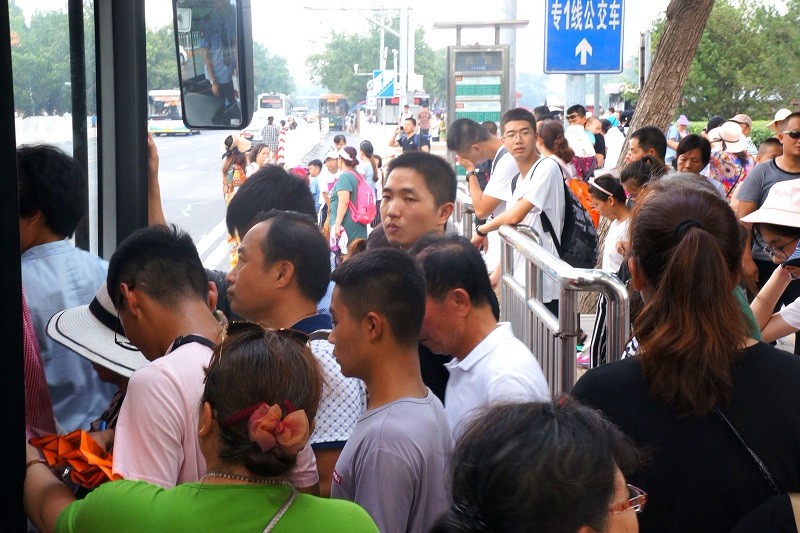 故宫北门,游客摩肩接踵,排队乘坐公交车.