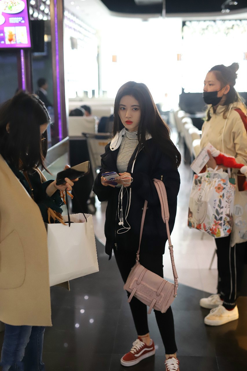 鞠婧祎穿黑色外套搭配黑色裤子现身机场,皮肤白皙面带微笑