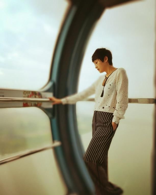 傅淼身穿一套深蓝色职业套装,搭配黑色高跟鞋,简单大方,搭配短发,更显