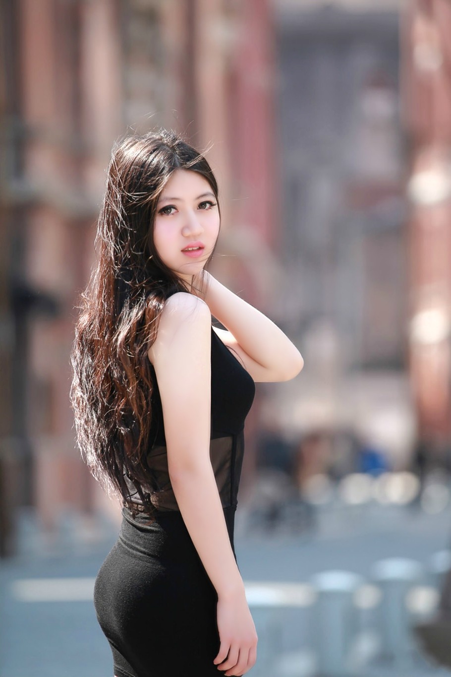 行走在夏日街头的一个长发飘飘清秀女孩