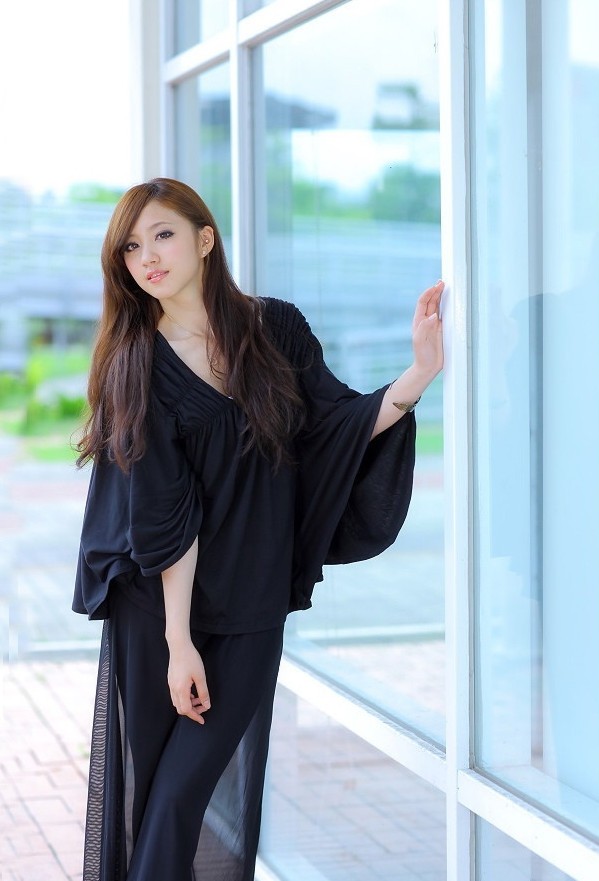 一个依偎在公园里的艳丽长发女孩