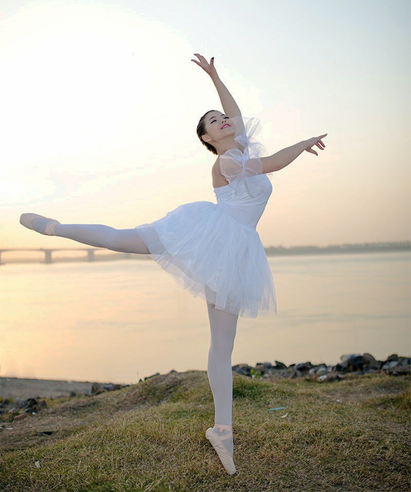 周末里一个在河边夕阳下的芭蕾舞女孩