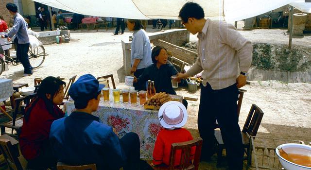 1984年西安珍贵历史老照片:图为一个卖茶水,汽水,小零食的小摊,一杯