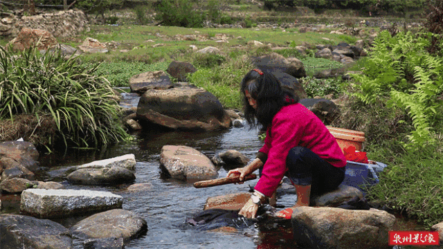 沾着水声,噼噼啪啪脆灵热闹有节奏地捶打衣物溪边有农妇手执棒槌给河