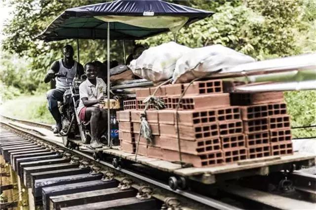 利用摩托车的代替人力,前轮固定在木质推车上,用后轮驱动整部车在火车