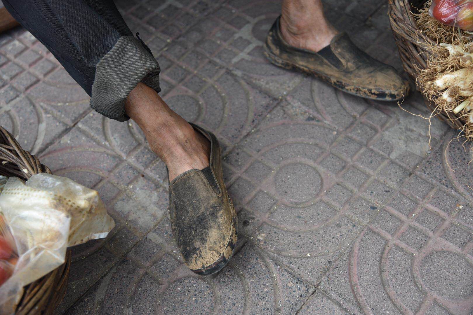 一根扁担,两只竹篮,这位在街头卖菜的老人,正在等待顾客