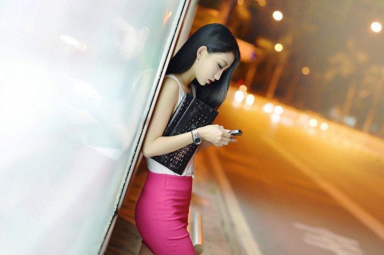 下班后一个人在公交站台边等车的美女