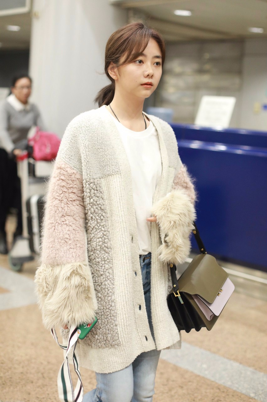 谭松韵穿开衫毛衣搭配蓝色牛仔裤现身机场,皮肤白皙面带微笑