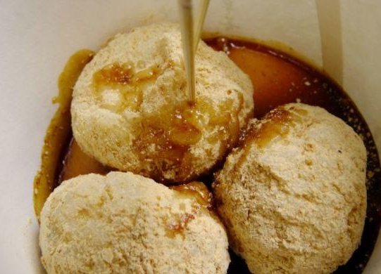 而已,吸引的是看稀奇的人,是现在热锅盆中抓出一大坨糍粑分为三小坨后