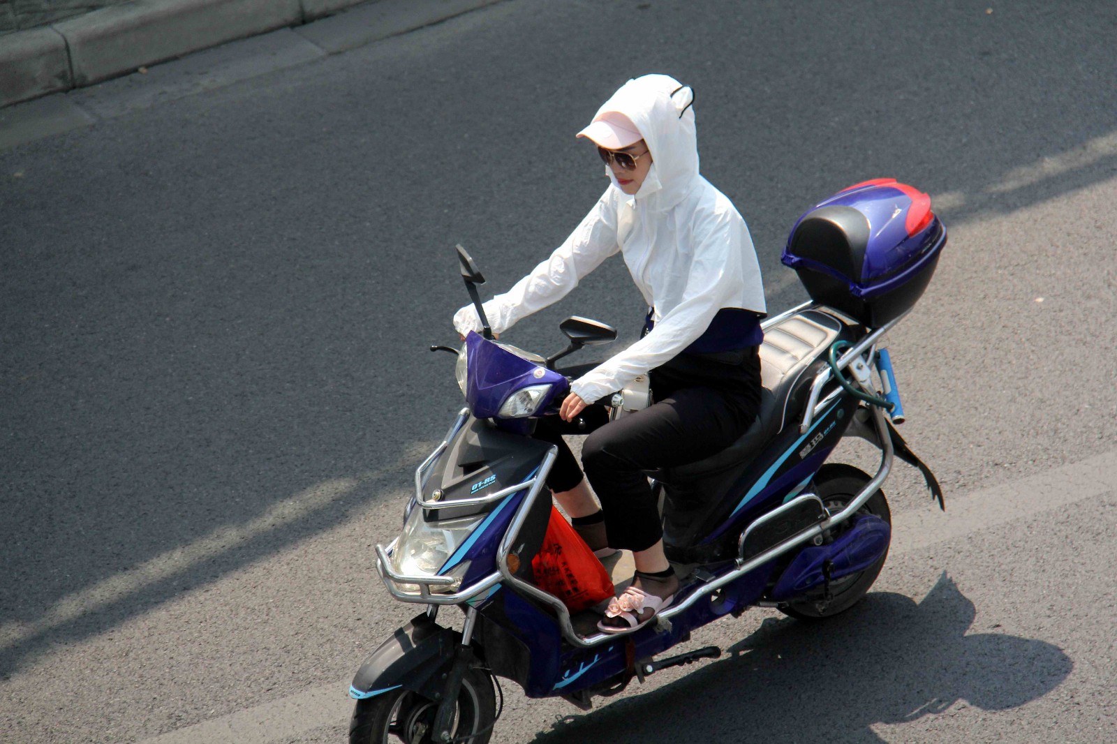安徽芜湖,高温来袭,室外温度突破35度以上,烈阳下,一位骑电动车的女子