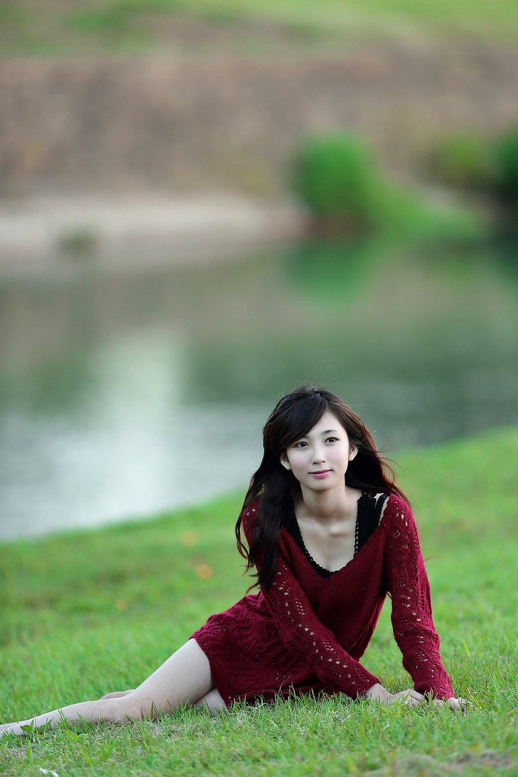 户外池塘边小草边的清秀佳人