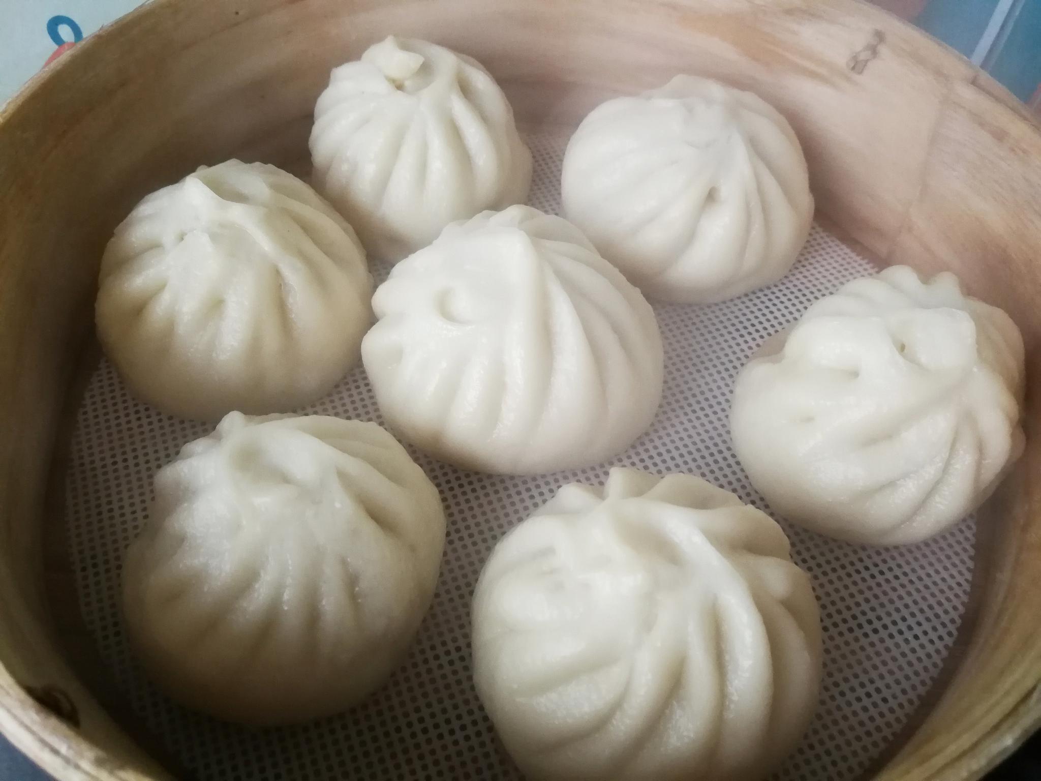 包成包子 5蒸锅倒入热水,将包子放入垫有烘焙纸的蒸屉中,摆上蒸锅,盖