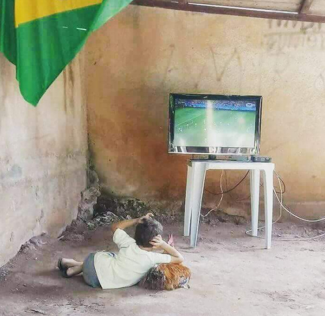 足球超越贫穷!一张巴西贫民窟小球迷看世界杯的照片走红!