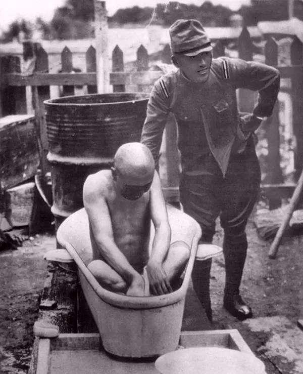 图为一名日军军官在战斗之后,在士兵的保护下洗澡.