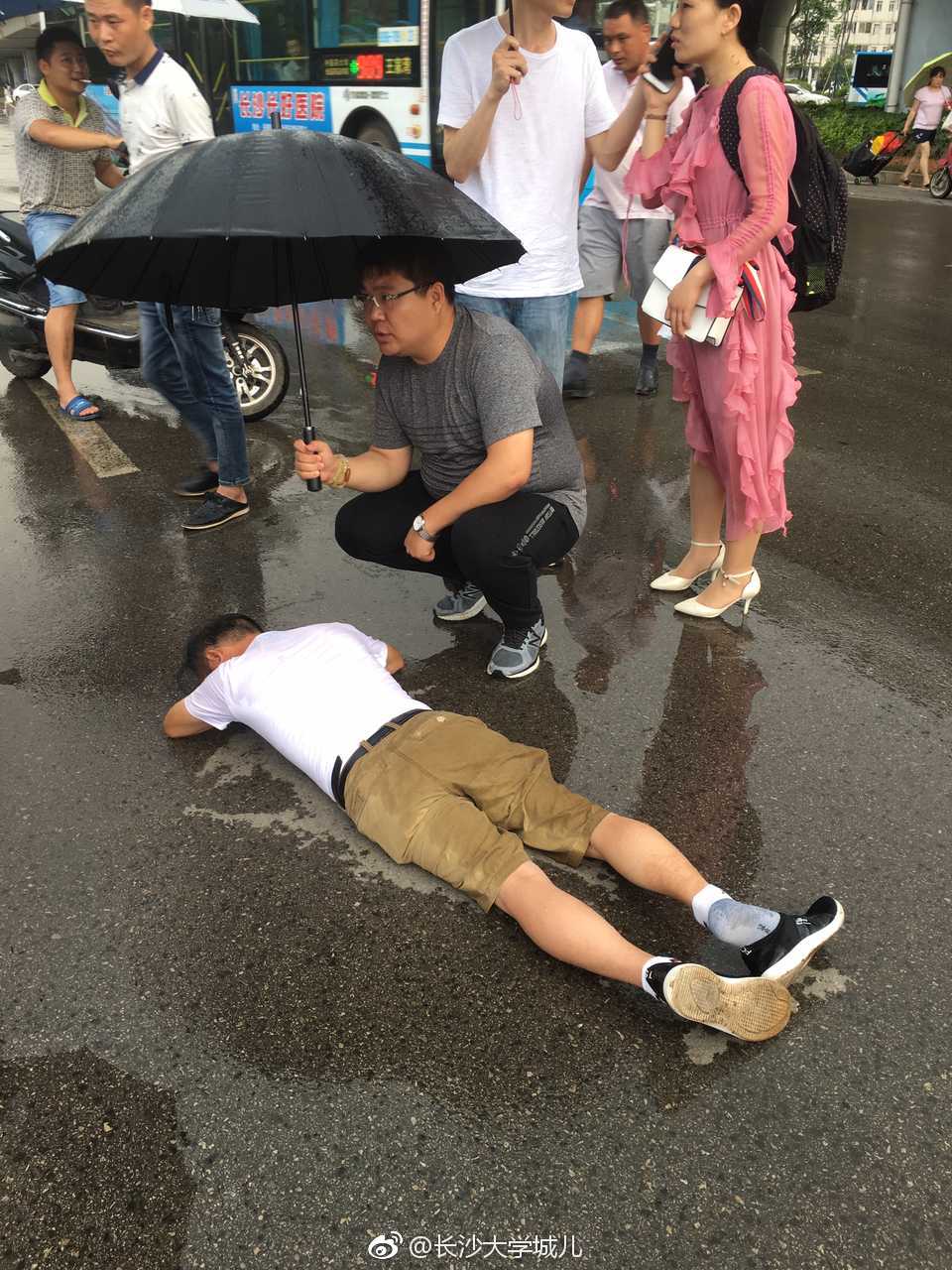 热心青年为摔倒老人雨中打伞报警求助